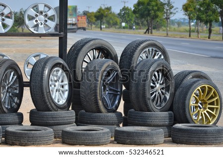 Alloy wheels with tires showing beside the road