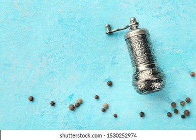 Allspice, Jamaica Pepper. Black Peppercorns With A Vintage Pepper Mill, Overhead Shot On A Blue Background With Copy Space. Culinary Flat Lay Design Template