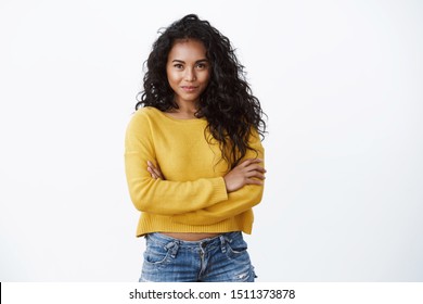 Alluring young african american female with dark curly hairstyle, smiling determined and motivated, cross arms chest confident pose, smiling daring camera, white background - Powered by Shutterstock