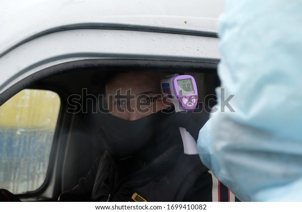 Almaty / Kazakhstan - 04.09.2020 : Medics\
check the temperature of drivers at the checkpoint during the\
coronavirus quarantine