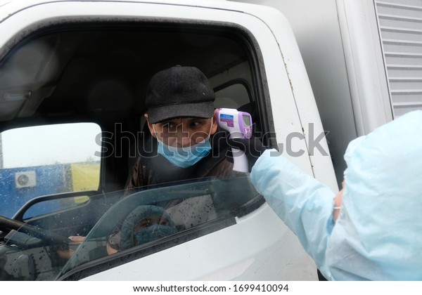 Almaty / Kazakhstan - 04.09.2020 : Medics\
check the temperature of drivers at the checkpoint during the\
coronavirus quarantine