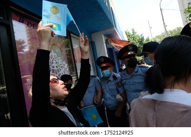 Almaty / Kazakhstan - 06.06.2020 : A woman holds a flag and a Constitution. Police detain protesting citizens because of the rally during the quarantine.