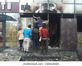 Almaty, Kazakhstan -07.01.2022: Workers rebuild the burned-out shop doors following a terrorist attack on the city of Almaty. From the left above the signature in Russian - "clothes and accessories"