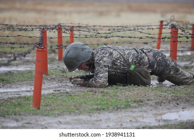 Almaty, Kazakhstan - 10.21.2014 : Soldiers Pass An Obstacle Course During A Military Exercise In The Rain