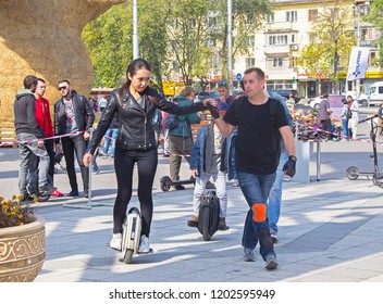 Almaty, Kazakhstan - 7 Oct 2018: Wheel Festival. Man Training Young Woman Riding On Self-balancing Electric Unicycle In City Square