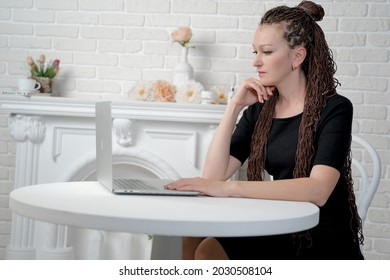 Almaty, Kazakhstan, July 12, 2021, A Female of European appearance poses at a table with an Apple laptop
