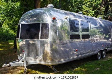 ALMATY, KAZAKHSTAN - JULY 27, 2017: Silver futuristic caravan Airstream on the glade in Panfilov park in the summer.