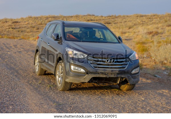 Almaty, Kazakhstan - September 12, 2015 : Photo\
of Damages of a dark-blue Hyundai Santa-fe vehicle after road\
accident on the sunset in\
prairie