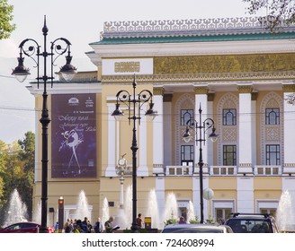 ALMATY, KAZAKHSTAN - September 22, 2017: Kazakh Opera And Ballet Theater (1941) With Play Bill Of 'Swan Lake' & Fountains &  Street Lights With Decorative Ironwork. 