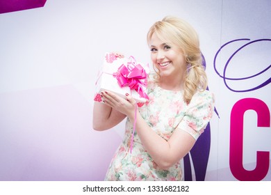 Almaty/Kazakhstan - January 19 2017: Beautiful Caucasian Girl Posing With The Gift Box Wrapped In Ribbon. Avon Sales Conference.