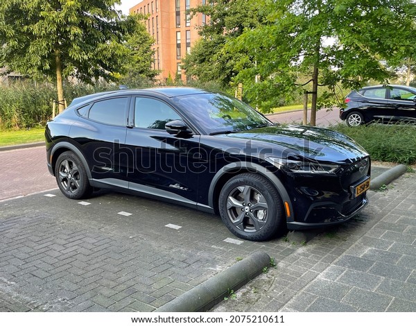 Almere,\
the Netherlands - August 20, 2021: Black Ford Mustang Mach-E\
electrical SUV parked on a public parking\
lot.