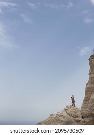 ALMERIA, SPAIN - Aug 19, 2021: A Vertical Shot Of Two Young Men About To Jump From A Cliff In Almeria, Spain