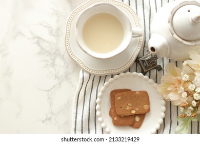 almond cookie on white plate with milk tea