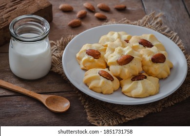 Almond cookies on plate and milk in glass bottle