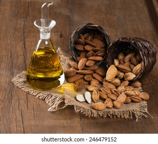 Almond kernels, whole and almond oil on rustic old wooden table