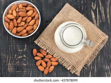 Almond Milk With A Bowl Of Nuts On A Dark Table, Top View