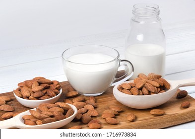 Almond Milk In Cup And Bottle With Almond Nuts On Wooden Background