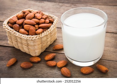 Almond Milk In Glass With Almonds On Wooden Table