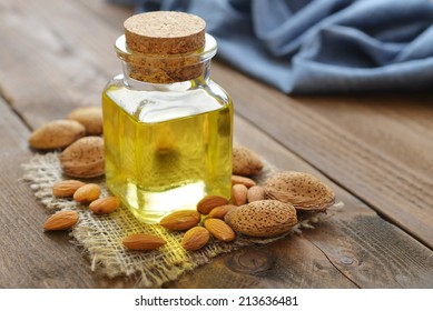Almond oil in bottle on wooden background