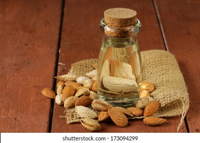 almond oil in a glass bottle with whole nuts