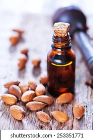 almond oil in a glass bottle with whole nuts