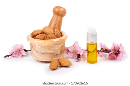 almond oil and almond nuts with flowers on white background