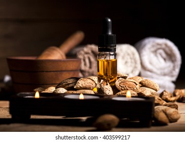 Almond oil and nuts on an old wooden background, selective focus