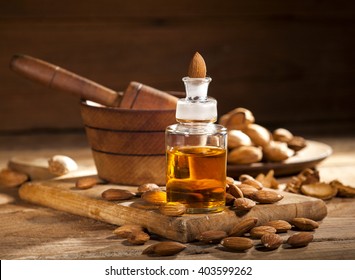 Almond oil and nuts on an old wooden background, selective focus