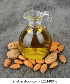 Almond oil with nuts on wooden background