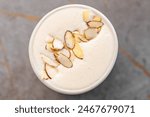 almond on a frothy beverage raf coffee in a white ceramic cup