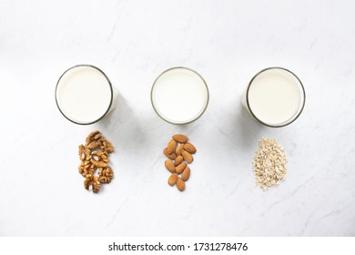 Almond, walnut, oat milk on marble background top view. Nut milk vegan lactose-free, dairy free milk drink. Health diet and nutrition. Stock photo. - Shutterstock ID 1731278476