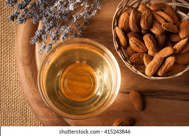 Almonds And Almond Oil On Wooden Background. Skin And Hair Care Concept. Lavender And Nuts.