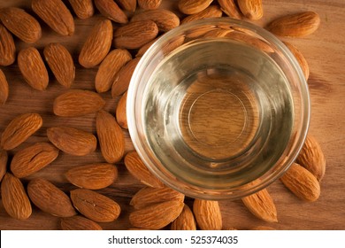 Almonds And Almond Oil On Wooden Background. Skin And Hair Care Concept. Lavender And Nuts.