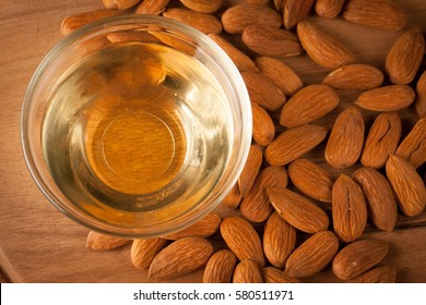 Almonds And Almond Oil On Wooden Background. Skin And Hair Care Concept. Lavender And Nuts.