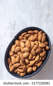 Almonds In Black Bowl On White Wooden Background, Almonds On White Wood Texture, Flatly Angle Photo Of Almonds