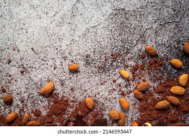 almonds, dark chocolate, cocoa powder on a gray neutral concrete background. Top view. Place and space for text