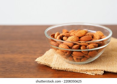 Almonds In Glass Bowl On Wooden Table Background