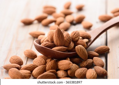 Almonds pour from wood spoon