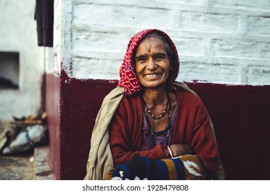 Almora, Uttrakhand - March 2 2021:- Old aged woman sitting with the support of the wall in the sunset wearing indian traditional dress and ancient jeweleries