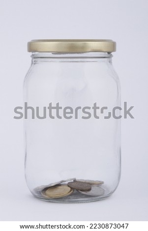 Almost empty jar with a few coins in it