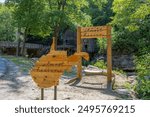 The "Almost Heaven" sign with the historic mill in the background at Babcock State Park, capturing West Virginia