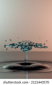 Almost Symmetrical Water Drop Splash Above Calm Dark Water