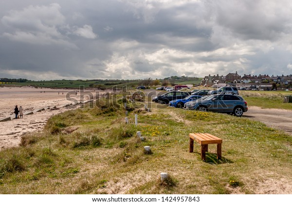 Alnmouth Beach and car park, Northumberland,\
England. 11 May 2019. Alnmouth beach with day trippers on the beach\
and the car park.\
