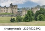 Alnwick, North Yorkshire, UK - June 28th 2023 - Panoramic view of Alnwick Castle across some fields on a hill