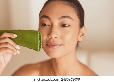 Aloe Skincare. Woman Holding Aloe Vera Leaf to Face for Skincare Treatment. Close-Up of Fresh, Natural Beauty Routine - Powered by Shutterstock