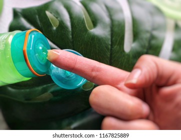 Aloe Vera Gel From Bottle On Hand In Blur Green Leaf