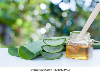 Aloe Vera Leaf With Aloevera Gel And Honey On Wooden Table With Green Nature Background.