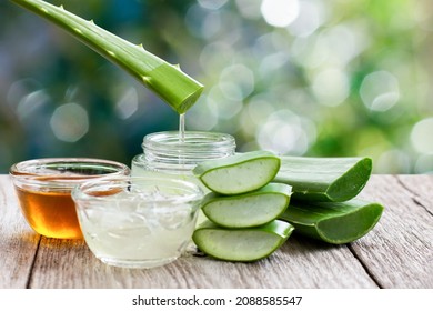 Aloe Vera Leaf With Aloevera Gel And Honey On Wooden Table With Green Bokeh Nature Background.