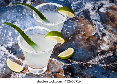 Aloe vera margarita cocktail with salty rim on marble table 