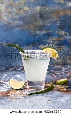 Aloe vera margarita cocktail with salty rim on marble table 

